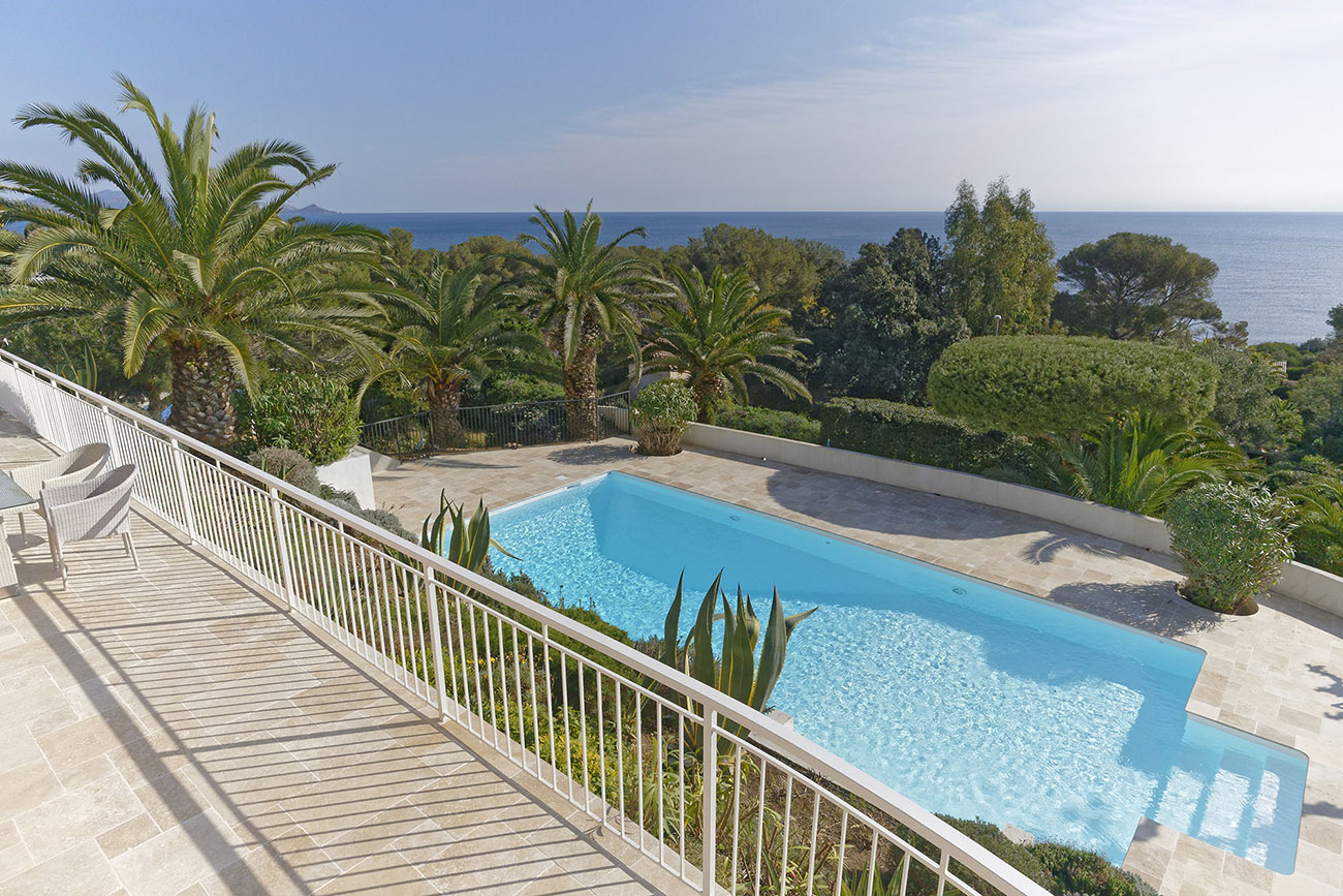 Der private Pool ist von einer großzügigen Sonnenterrasse und einem gepflegten Garten umgeben. Der weite Blick über die Küste begleitet ruhige Stunden am Wasser.
